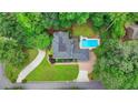 Aerial view of a home featuring a swimming pool, well-manicured lawn, and mature trees at 5025 Oak Bluff Ct, Atlanta, GA 30350