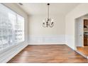 Bright dining room featuring wood floors, wainscoting and large windows at 789 Clairidge Elm Sw Trl, Lawrenceville, GA 30046