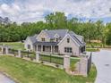Beautiful brick home with a lush green lawn, secure black iron fence, and long concrete driveway at 140 Maranatha Trl, Lawrenceville, GA 30045
