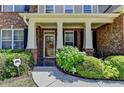 Inviting home entrance with decorative pillars, a tiled porch, and colorful landscaping at 25 Kaktovic Ct, Grayson, GA 30017