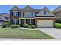 Charming two-story home featuring a brick facade, attached garage, and well-manicured lawn at 25 Kaktovic Ct, Grayson, GA 30017