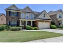 Charming two-story home featuring a brick facade, attached garage, and well-manicured lawn at 25 Kaktovic Ct, Grayson, GA 30017