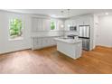 Modern kitchen with white cabinetry, stainless steel appliances, and center island with sink at 2714 Eagles Crest Ln, Decatur, GA 30034