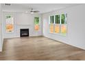 Bright living room with wood floors, a modern fireplace, and large windows offering natural light and backyard views at 2432 Whites Rdg, Decatur, GA 30034
