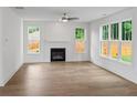 Bright living room with wood floors, a modern fireplace, and large windows offering natural light and backyard views at 2432 Whites Rdg, Decatur, GA 30034