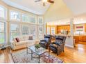 Bright living room with large windows, hardwood floors, and an open layout to the kitchen at 2810 Promenade Pl, Buford, GA 30519