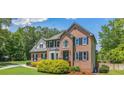 Beautifully maintained brick home featuring a manicured front lawn and mature shrubbery, complemented by black window shutters at 65 Millennial Ct, Lawrenceville, GA 30045