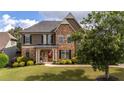 Stunning home showcasing a stone and stucco facade, lush landscaping, and a welcoming front entrance at 208 Eagles Flight, Villa Rica, GA 30180