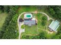 Aerial view of the property showcasing the house, pool, barn, and surrounding greenery at 2997 Happy Hollow Se Dr, Conyers, GA 30094
