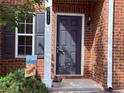 Close up of front door with black shutters and a small decorative flower pot at 5620 Moresby Ct, Alpharetta, GA 30022