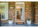 Welcoming front entrance featuring a white door, planters, and charming exterior brickwork at 3792 Harts Mill Ne Ln, Brookhaven, GA 30319