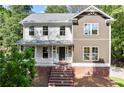 Beautiful two-story home with a brick foundation, charming front porch, and manicured landscaping at 5150 Shadow Path Sw Ln, Lilburn, GA 30047