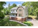Charming two-story home with a brick foundation, front porch, and lush green lawn at 5150 Shadow Path Sw Ln, Lilburn, GA 30047