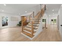 Bright foyer featuring hardwood floors, modern staircase with black railings, and an abundance of natural light at 5150 Shadow Path Sw Ln, Lilburn, GA 30047