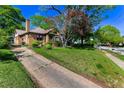 Beautiful brick home with a green lawn, mature trees, and driveway to the side at 1029 Katherwood Sw Dr, Atlanta, GA 30310