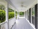 Inviting covered front porch with classic white columns and ceiling fans, perfect for enjoying the outdoors at 253 Pine Valley Dr, Powder Springs, GA 30127