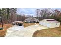 Home exterior with a carport, well-manicured lawn and an adjacent storage building with garage doors at 7460 Highway 101 N, Rockmart, GA 30153