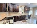 Kitchen featuring custom dark wood cabinets, granite counters, stainless appliances and tile backsplash at 7460 Highway 101 N, Rockmart, GA 30153