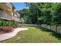 Grassy backyard framed by a white fence and lush trees, offering privacy and a serene outdoor space at 1202 Laurel Cliff Se Dr, Smyrna, GA 30082