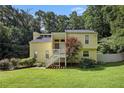 Two-story home with a well-manicured lawn and charming staircase entry nestled amongst mature trees at 1202 Laurel Cliff Se Dr, Smyrna, GA 30082