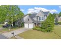 Lovely gray home on a manicured lot, showcasing a two-car garage and inviting curb appeal at 3525 Elder Field Ln, Cumming, GA 30040