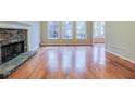 Bright living room featuring hardwood floors, stone fireplace, and large windows at 402 Hancock Ct, Woodstock, GA 30188