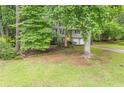 Split-level home with a bright yellow front door and mature trees in the yard at 4171 Whispering Forest Sw Ct, Lilburn, GA 30047