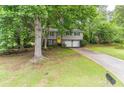 Suburban home with a bright yellow front door, attached two-car garage, and driveway at 4171 Whispering Forest Sw Ct, Lilburn, GA 30047