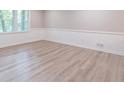 Bright room with vinyl plank flooring, wainscoting, and natural light through a large window at 4171 Whispering Forest Sw Ct, Lilburn, GA 30047
