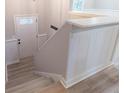 Staircase featuring light gray wood floors, leading to a white door with glass inserts and white wainscoting at 4171 Whispering Forest Sw Ct, Lilburn, GA 30047