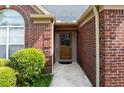 Inviting front entrance featuring a brown door, brick surround, and well-maintained landscaping at 4584 Brook Farms Dr, Duluth, GA 30096