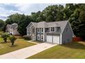 A charming two-story home with a stone facade and well-manicured lawn, nestled among mature trees at 1583 Rogers Crossing Dr, Lithonia, GA 30058