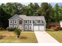 A charming two-story home with a stone facade, set on a well-manicured lawn with mature trees at 1583 Rogers Crossing Dr, Lithonia, GA 30058