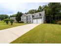 Charming two-story home with a stone facade, featuring an expansive driveway and a well-manicured front lawn at 1583 Rogers Crossing Dr, Lithonia, GA 30058