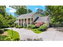 A beautiful home featuring well-manicured lawns, professional landscaping, and a three-car garage at 7590 Chaparral Dr, Atlanta, GA 30350