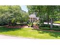 Traditional home featuring an expansive, beautifully manicured front lawn and mature trees at 7590 Chaparral Dr, Atlanta, GA 30350