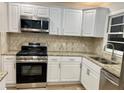 This kitchen features stainless steel appliances, granite countertops, and ample white cabinetry at 1607 Hillview, Jonesboro, GA 30236