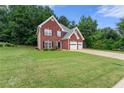 Beautiful brick home with a lush green lawn and attached two car garage at 2994 Meadow Church Rd, Suwanee, GA 30024