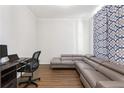 Home office with a comfortable gray couch, desk, and chair with hardwood floors at 803 Levi Farms Ln, Canton, GA 30115