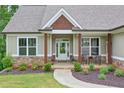 Inviting covered front porch with seating area, beautiful stone accents, and a well-manicured lawn at 10 Berryhill Se Pl, Cartersville, GA 30121