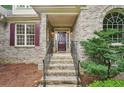 Inviting front entrance featuring brick steps, wrought iron railings, arched window, and a stylish front door at 2297 Herring Woods Way, Grayson, GA 30017
