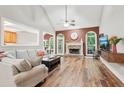 Bright living room with vaulted ceiling, fireplace, wood floors, and large windows that offers lots of natural light at 2297 Herring Woods Way, Grayson, GA 30017