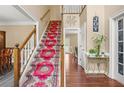 Inviting foyer with a grand staircase featuring a vibrant runner and hardwood floors at 2641 Loch Way, Snellville, GA 30039