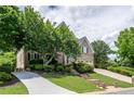 Beautiful brick home with a well-kept lawn, mature trees, and a long driveway leading to the garage at 5589 Forkwood Nw Dr, Acworth, GA 30101