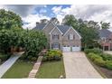 Aerial view of a brick home boasting lush landscaping, a two-car garage, and inviting curb appeal at 5589 Forkwood Nw Dr, Acworth, GA 30101