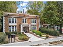 Brick building featuring a beautifully landscaped entrance walkway and mature trees at 242 12Th Ne St # 14, Atlanta, GA 30309