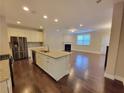 Open concept kitchen with stainless steel appliances, granite countertops, and hardwood floors at 8265 Village Pl, Suwanee, GA 30024