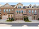 Charming brick townhome featuring a two-car garage, dormer windows, and inviting front porch at 1590 Ridgebrook Downs, Mableton, GA 30126