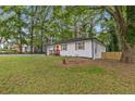 Landscaped front yard with a freshly painted exterior, new driveway, and mature trees at 1927 Willa Way, Decatur, GA 30032