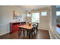 Classic dining room with a statement chandelier, wood floors, and elegant wainscoting at 207 Harmony Lake Dr, Canton, GA 30115